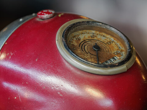 Detail of a vintage analogue speedometer on a classic motorcycle.