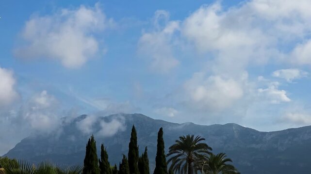 Timelapse of dense clouds forming over Montgo mountain peak due to humid sea wind orographic lift in Denia, Spain. Ideal for meteorology, weather science, nature, and background videos.