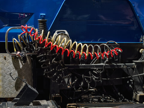 Detail of pneumatic hoses at the rear of a semi-truck tractor.
