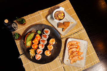 Refeição de sushi com vista zenital em mesa escura com espaço para texto © Matheus