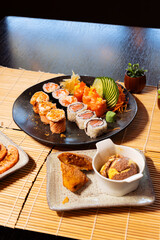 Refeição de sushi com vista zenital em mesa escura com espaço para texto © Matheus