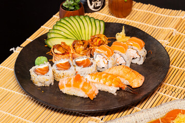 Refeição de sushi com vista zenital em mesa escura com espaço para texto © Matheus