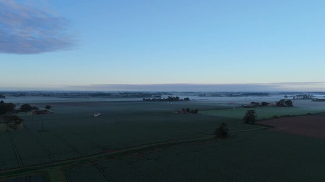 Soft dawn light paints the rural fields
