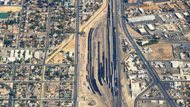 Aerial view, nearly straight down, of a railroad yard and its surrounding industrial and residential neighborhoods in Bakersfield, California, forming interesting patterns of lines and colors.