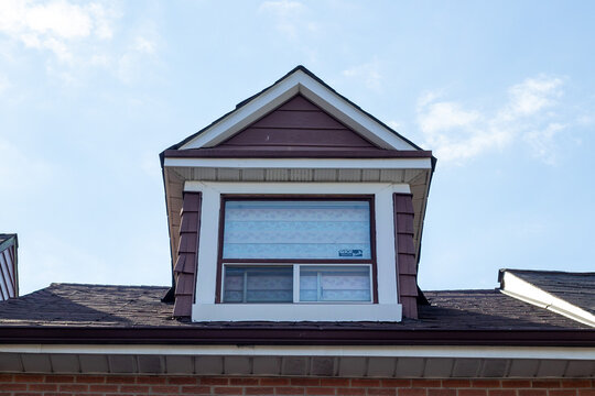 House dormer window with shingle roof against sky