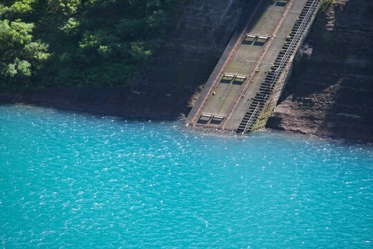 美しい四万ブルーの水面へと続く四万川ダムのインクラインと奥四万湖 Incline structure extending into emerald blue water of Okushima Lake at Shima River Dam