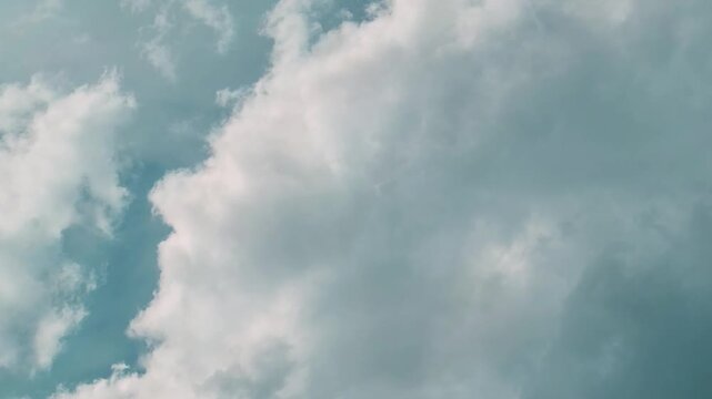 Fluffy white clouds against a soft blue sky