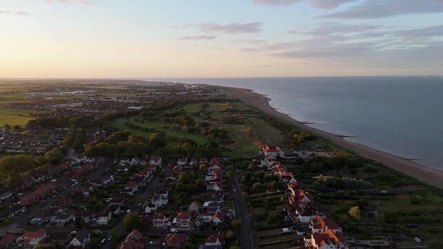 Golden light bathes coastal town and sea
