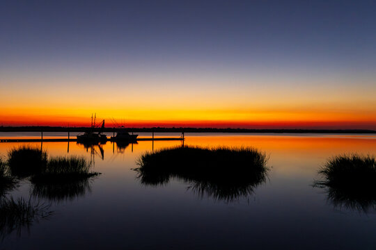 Fishing boats docked at marsh harbor during vivid sunset