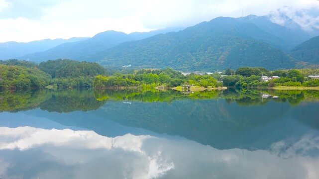 Emerald Blue Pond Reflection of Mountains and Sky at Ikeda Pond Niihama Ehime Japan