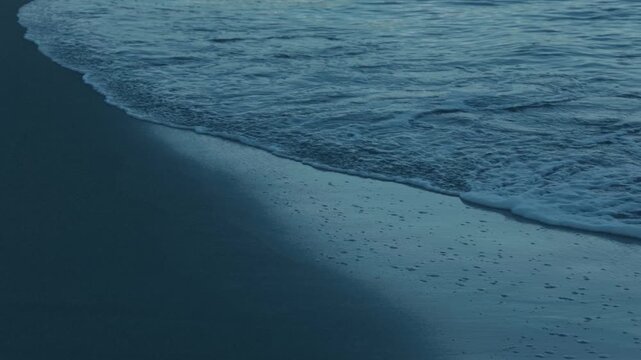 Gentle Waves Lapping Quietly on a Dark Blue Beach