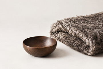 Curled karakul wool fleece and dark wooden bowl. © you