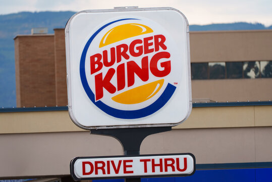 Store signage of Burger King Corporation (also known as BK), an American fast food chain of hamburger fast food restaurants. Sign also indicates this location offers drive-thru service.