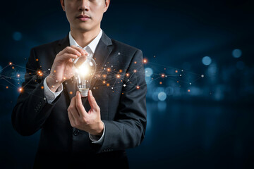 Businessman holding a glowing light bulb symbolizing new ideas and innovation. © Surjukanto Arts