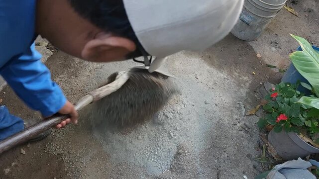 Young Man Hands Mixing Dry Cement And Sand With Shovel