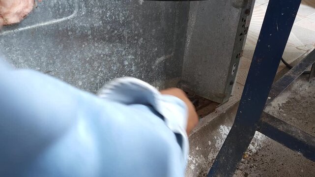 Scraping Heavy Rust Off Stove Base With Screwdriver Tool