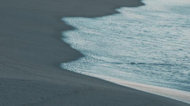 Close-Up of Gentle Waves Lapping Against a Dark Blue Shore