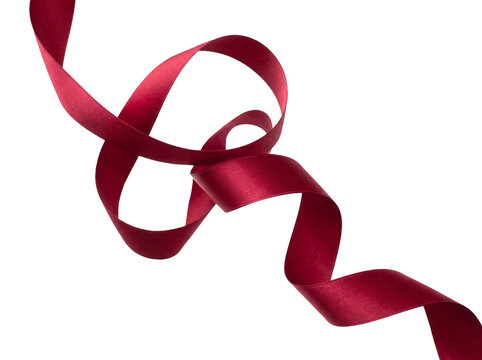 Elegant flowing dark red silk ribbon isolated on a solid black background for festive holiday design