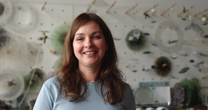 Older adult woman art glasswork studio owner posing for promotional business portrait looking at camera with smile representing handmade product branding and creative industry entrepreneurship success