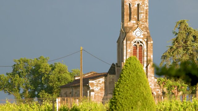 Historic Stone Church Spire in Saint-Emilion Vineyards with Stormy Sky