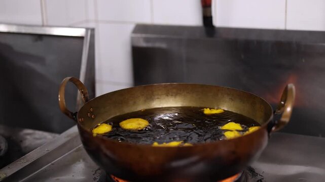 Deep Frying Indian Pakoras in Hot Oil Inside Brass Karahi Pan