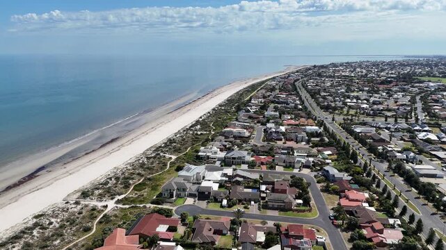 Aerial drone view overlooking the suburb of West Lakes Shore, Adelaide, South Australia. Rows of beachside residential homes, coastal dune vegetation, walking trail and&nbsp;a long stretch of sandy beach