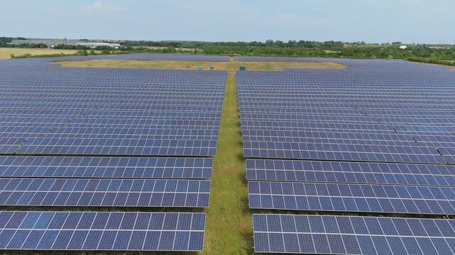 Rows of solar panels stretch across a green field