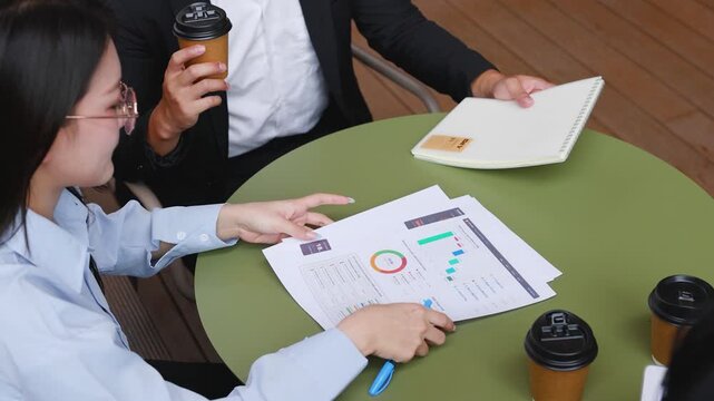 Asian Businesspeople Discussing Documents at Office Cafe Table Overhead View
