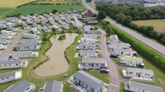 Aerial view shows a quiet caravan park with a central pond