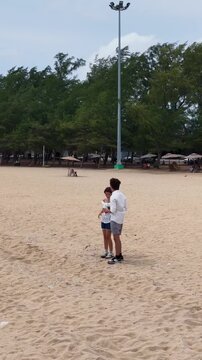 Young Couple Standing on a Sandy Beach Taking Photos in Rayong