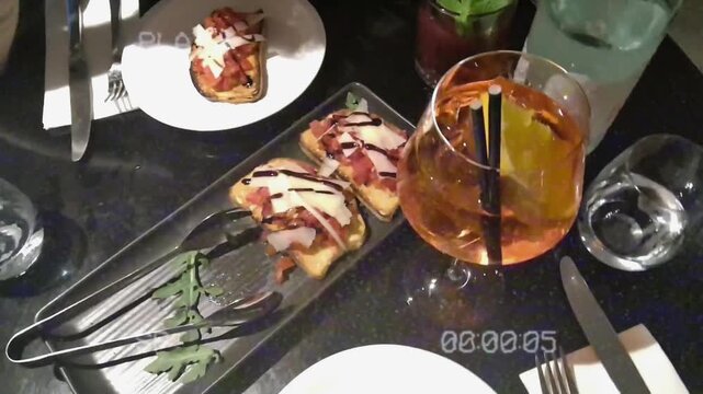 Aperol spritz cocktail and bruschetta appetizers on a restaurant table