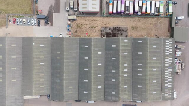 Aerial view of warehouse complex with trucks and parked vehicles