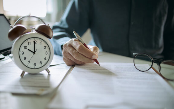 close up shot, businessman hand holding pen reviewing business document, professional lawyer working on desk checking financial report, business contract