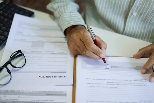 close up shot, businessman hand holding pen checking business contract and personal loan from before sign to start new business, online business, E-commerce