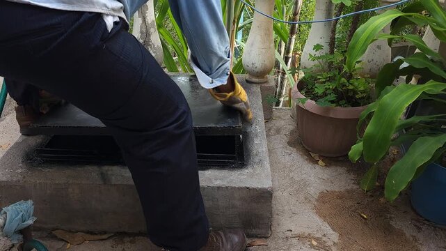 Adjusting Metal Water Cistern Lid In Outdoor Yard