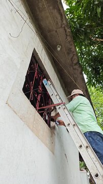 Pouring Paint On Cloth To Touch Up Window Frame At Height
