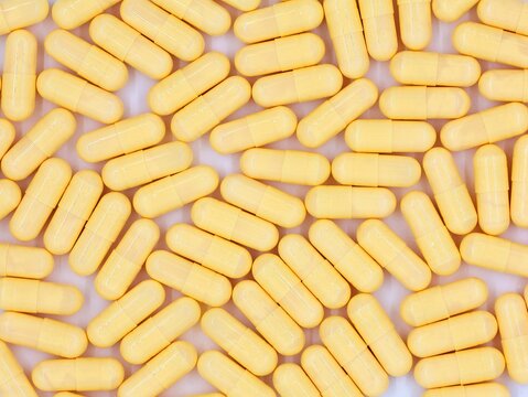 Yellow capsules, isolated on a white background. Top view of pills. Background with medication.