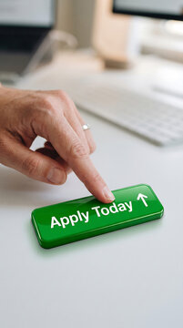 Person pressing green apply today button on office desk workspace