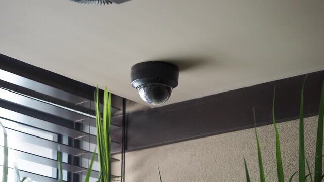 Security camera surveillance system installed on office ceiling monitoring indoor business.