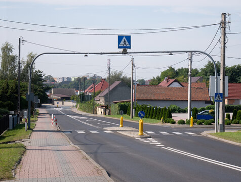 Przejście dla pieszych z sygnalizacją świetlną w podmiejskim rejonie zachodniej Polski o letniej porze