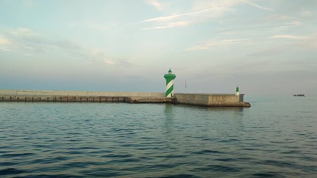 Green lighthouses on a concrete pier at sea