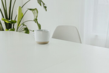 Fototapeta premium Minimalist scene of a coffee cup on a white table
