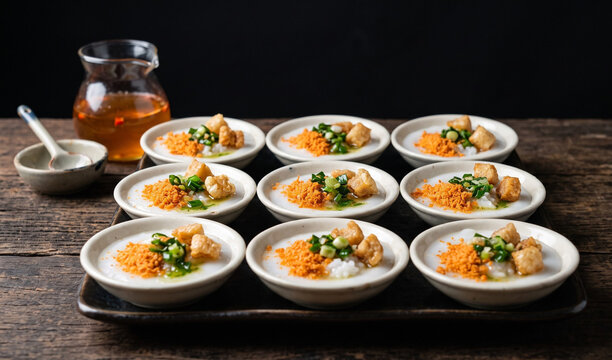 Banh Beo (Steamed Rice Disks): Small, shallow ceramic saucers holding delicate white steamed rice disks topped with orange dried shrimp powder, 