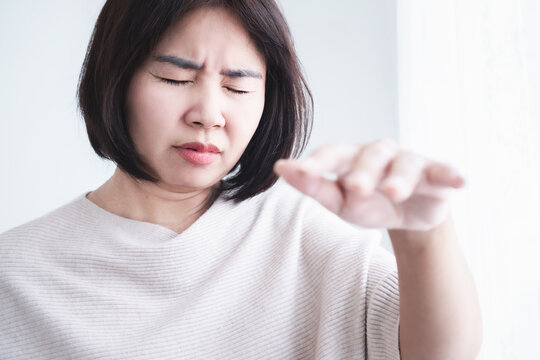 
Asian woman suffering from dizziness, vertigo symptom, fainting, closing eyes and reaching hand out for balance, feeling disoriented, sick, lightheadedness, medical healthcare illness concept