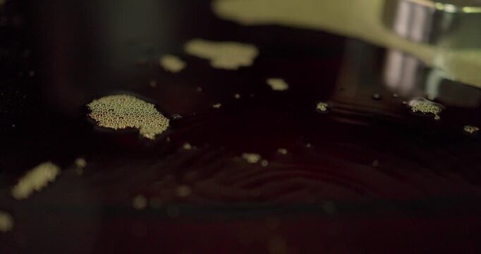 Macro of cutting fluid and fine metal chips on a machined steel mould surface in a factory