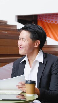 Asian Businessman Discussing Documents in Modern Coworking Office Space