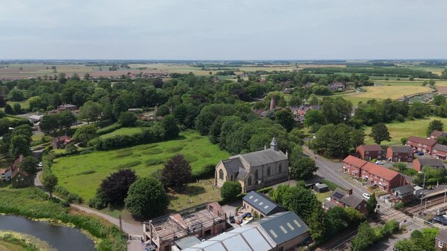 Aerial view of quiet village surrounded by green fields and trees
