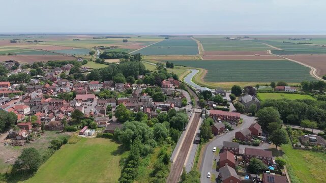 Aerial view of small village surrounded by green fields