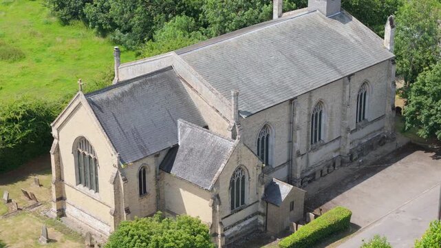 Stone church rises above lush green trees