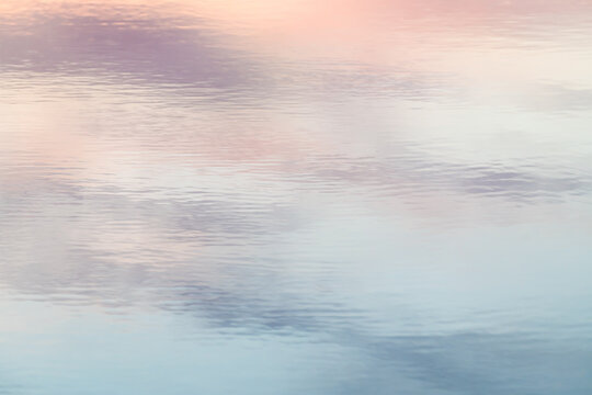 Calm water surface reflecting a sunset sky
